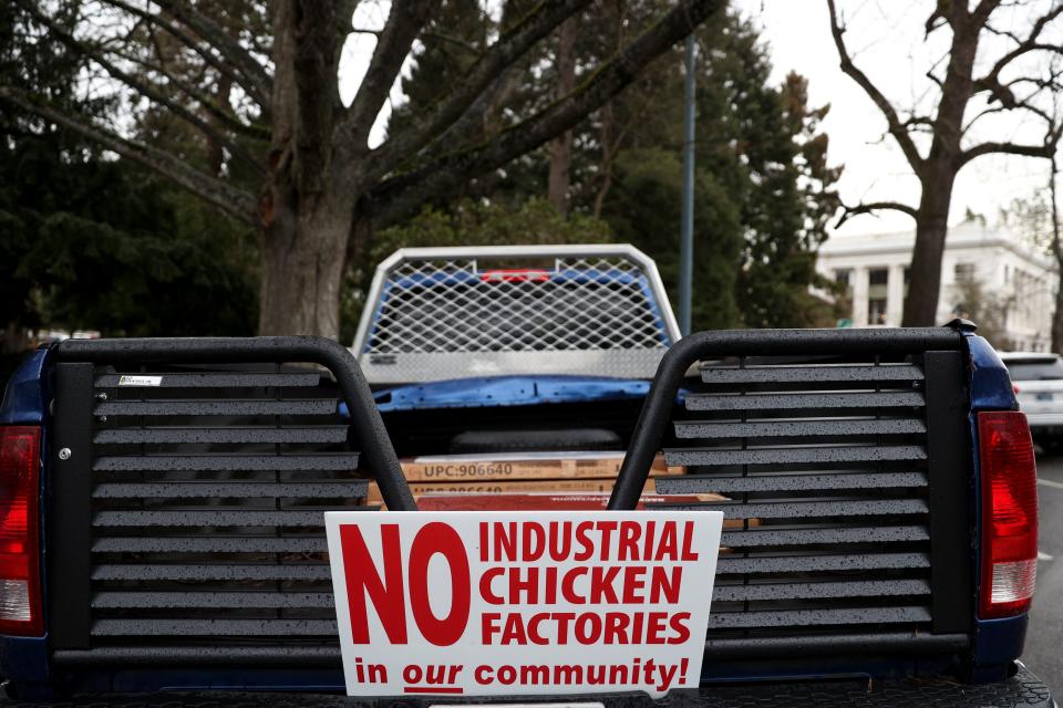 A truck with a sign opposing industrial chicken factories is parked Monday near the Oregon State Capitol prior to a Senate Committee on Natural Resources public hearing.