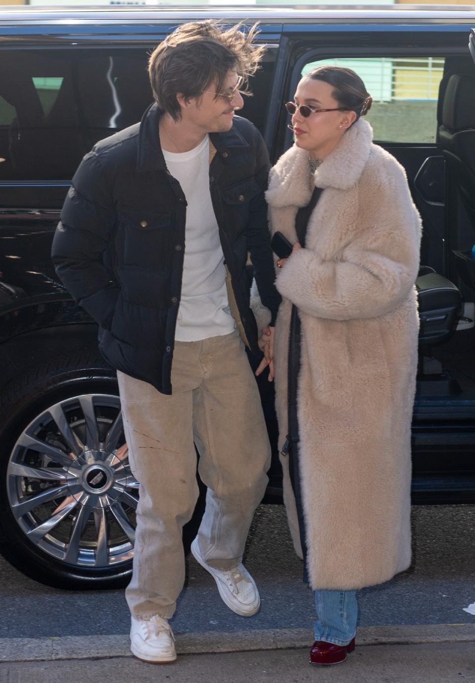 the two holding hands after getting out of the car. They are both wearing coats