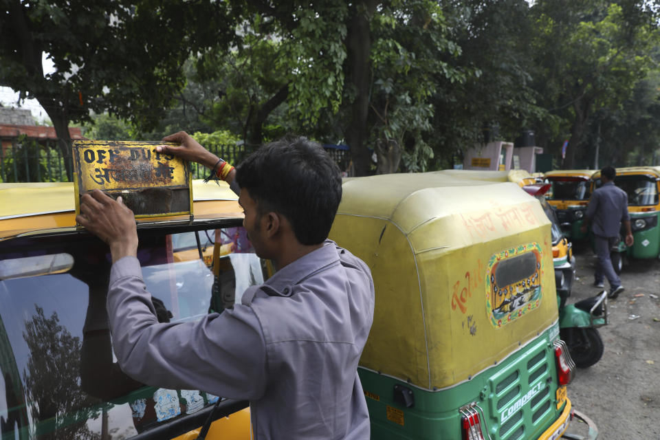 An auto-rickshaw driver puts up off duty board during a public transport strike in New Delhi, India, Thursday, Sept. 19, 2019. Commuters in the Indian capital are facing problems as a large section of the public transport, including private buses, auto-rickshaws and a section of app-based cabs Thursday remained off the roads in protest against a sharp increase in traffic fines imposed by the government under a new law.(AP Photo/Manish Swarup)