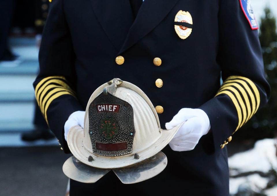 Kittery Fire Chief David W. O'Brien carries the helmet of retired chief, George D. Varney Jr. at the First Congregational Church United Church of Christ in Eliot Tuesday, Jan. 18, 2022.