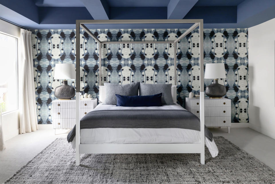 This image provided by LifeCreated shows a bedroom. A deep indigo on the ceiling of this modern Paradise Valley, AZ home is echoed in a soft velvet pillow, and Eskayel's Galileo Glass wallpaper. Scottsdale, AZ-based design firm Living with Lolo's Lauren Lerner says 'colors with soothing tones have the power to evoke feelings of comfort and warmth.' (Stephanie Studer/LifeCreated via AP)