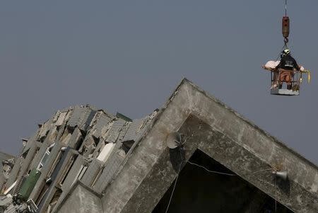 Rescue workers remove people from the site where a 17-storey apartment building collapsed after an earthquake hit Tainan, southern Taiwan February 7, 2016. REUTERS/Tyrone Siu