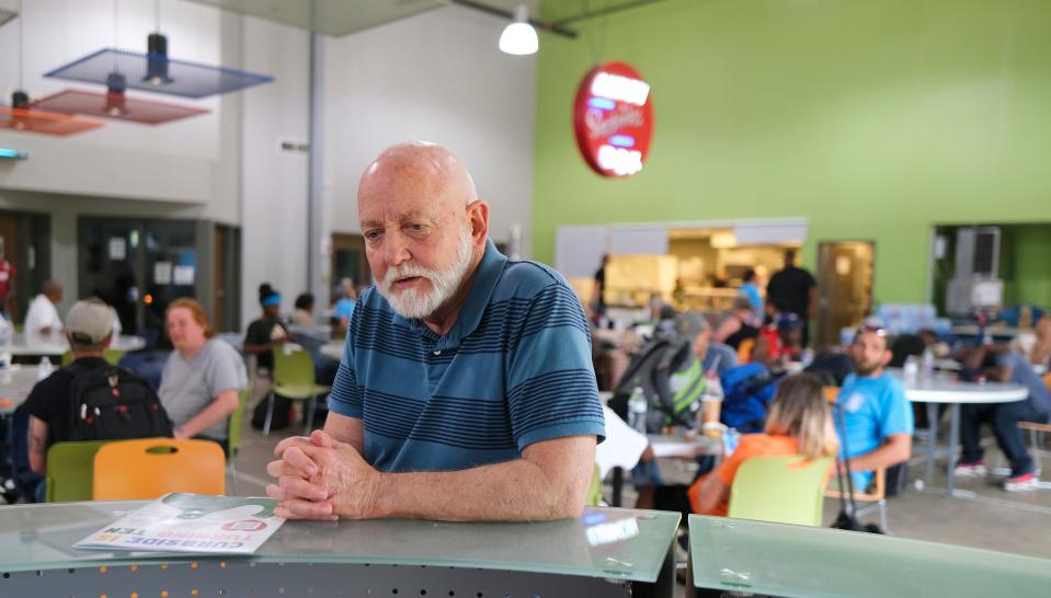 Dan Straughan, executive director of the Homeless Alliance, sits in the nonprofit's cafeteria. Hanging in the background is the historic sign for the now-closed downtown restaurant Lunch Box, where the idea for the Homeless Alliance was forged.