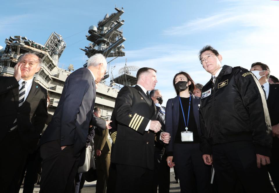 Japanese Prime Minister Fumio Kishida, right, visits the USS Ronald Reagan, in Sagami Bay, southwest of Tokyo, Sunday, Nov. 6, 2022. Kishida, at an international fleet review Sunday, said his country urgently needs to build up military capabilities as it faces worsening security environment in the East and South China Seas and threats from North Korea’s nuclear and missile advancement and Russia’s war on Ukraine.(Kyodo News via AP)