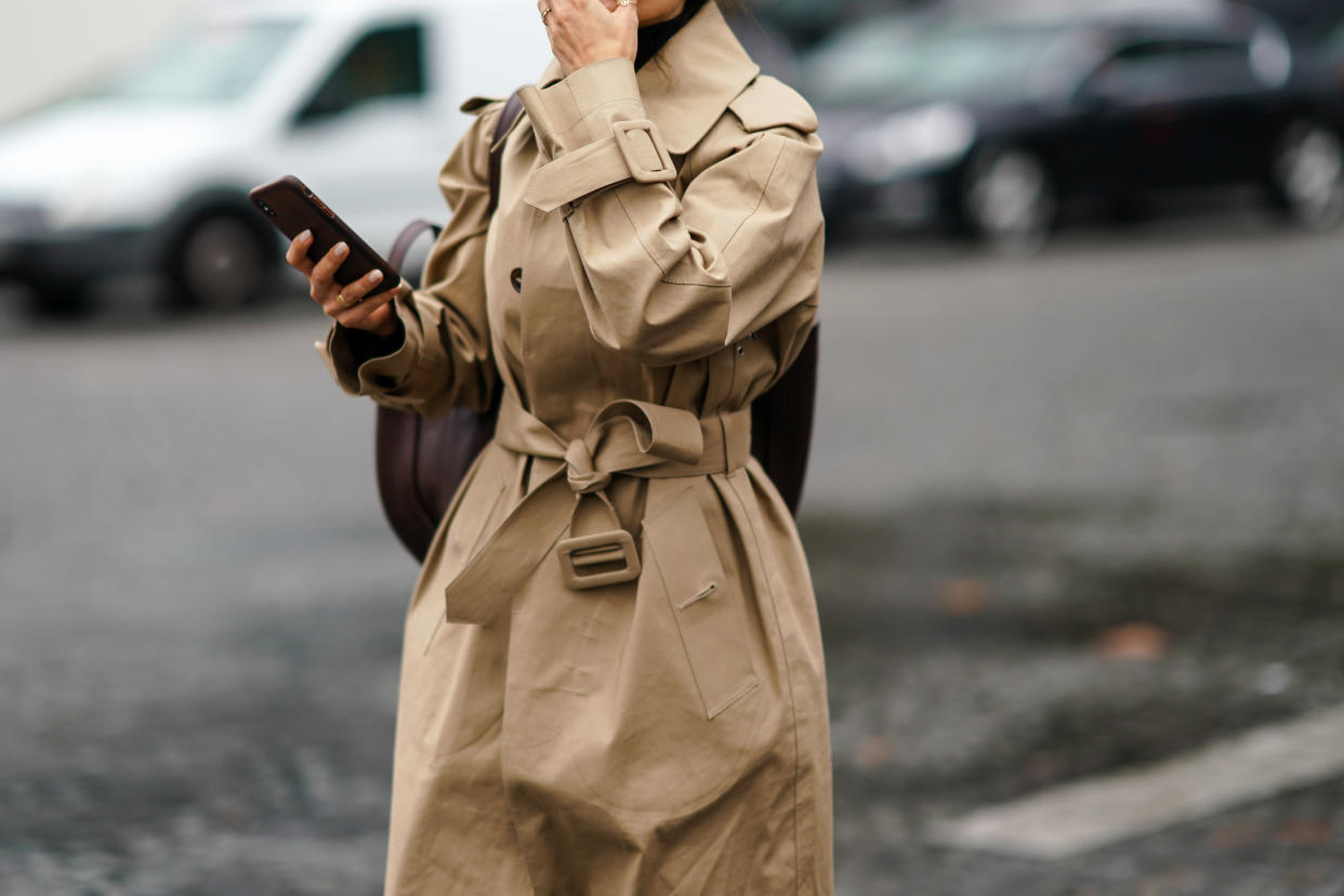 A guest wears a beige trench coat, outside Chanel, during Paris Fashion Week in October 2019 [Photo: Getty]