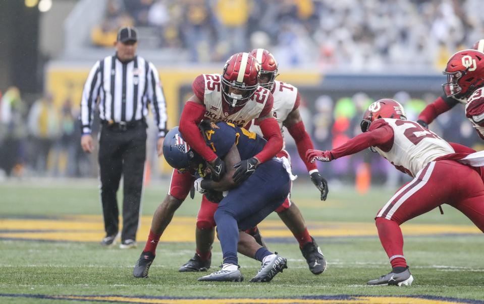 Nov 12, 2022; Morgantown, West Virginia, USA; Oklahoma Sooners defensive back Justin Broiles (25) tackles West Virginia Mountaineers running back Tony Mathis Jr. (24) during the first quarter at Mountaineer Field at Milan Puskar Stadium. Mandatory Credit: Ben Queen-USA TODAY Sports