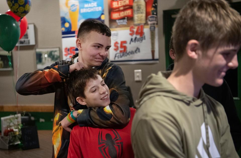 Tre Schapker shares a noogie with his buddy, Aslan Templeton, 13, at Froggy's Restaurant in Wadesville, Ind., during Schapker's 14th birthday party Friday night, Jan. 20, 2023.