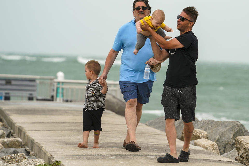 Max Muntean, 6 months, is held by his father, Gabriel Muntean, who lifts Max up so he can feel the wind, in Pass-a-Grille, Fla., Wednesday, April 10, 2024. (Martha Asencio-Rhine/Tampa Bay Times via AP)
