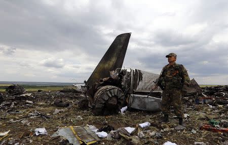 An armed pro-Russian separatist stands guard at the site of the crash of the Il-76 Ukrainian army transport plane in Luhansk June 14, 2014 REUTERS/Shamil Zhumatov