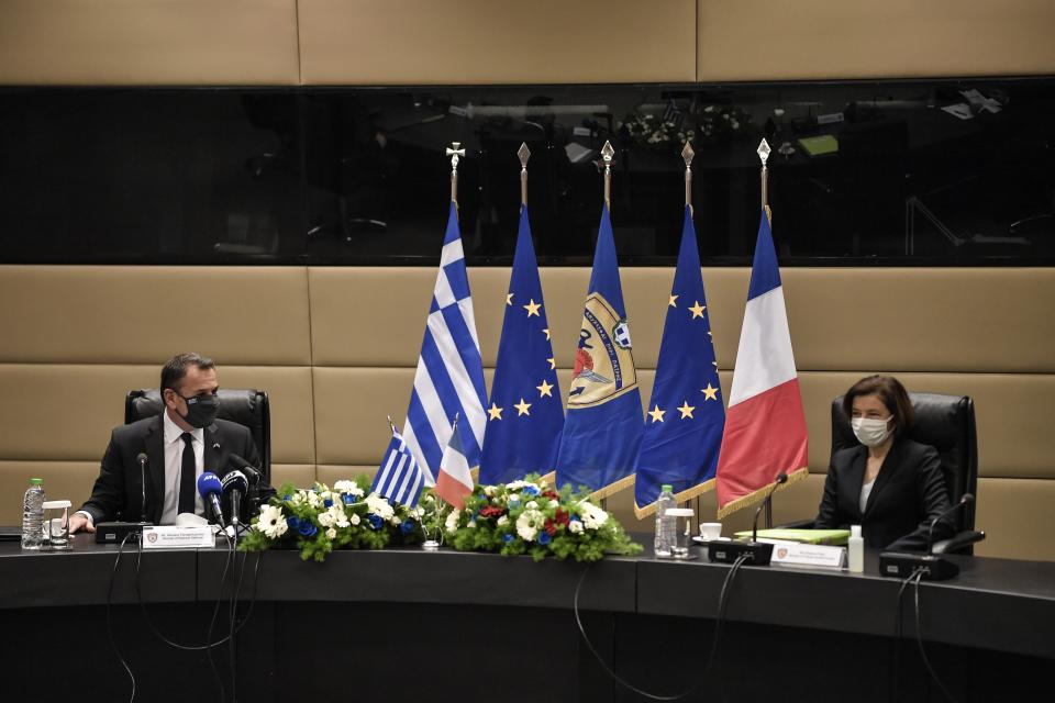 French Defense Minister Florence Parly, right, and his Greek counterpart Nikos Panagiotopoulos speak during their meeting in Athens, Monday, Jan. 25, 2021. Greece is due to sign a 2.3 billion euro ($2.8 billion) deal with France Monday to purchase 18 Rafale fighter jets to address tension with neighbor Turkey. (Louisa Gouliamaki/Pool via AP)