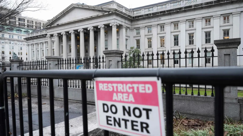 The Treasury Department building. A sign in the foreground, attached to a fence, reads: Restricted area. Do not enter.