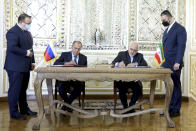 In this photo released by the Iranian Foreign Ministry, Iranian Foreign Minister Mohammad Javad Zarif, center right, and his Russian counterpart Sergey Lavrov, center left, sign agreements after their talks in Tehran, Iran, Tuesday, April 13, 2021. Iran's foreign minister warned Tuesday that an attack on its main nuclear enrichment site at Natanz affects ongoing negotiations in Vienna over its tattered atomic deal with world powers. (Iranian Foreign Ministry via AP)