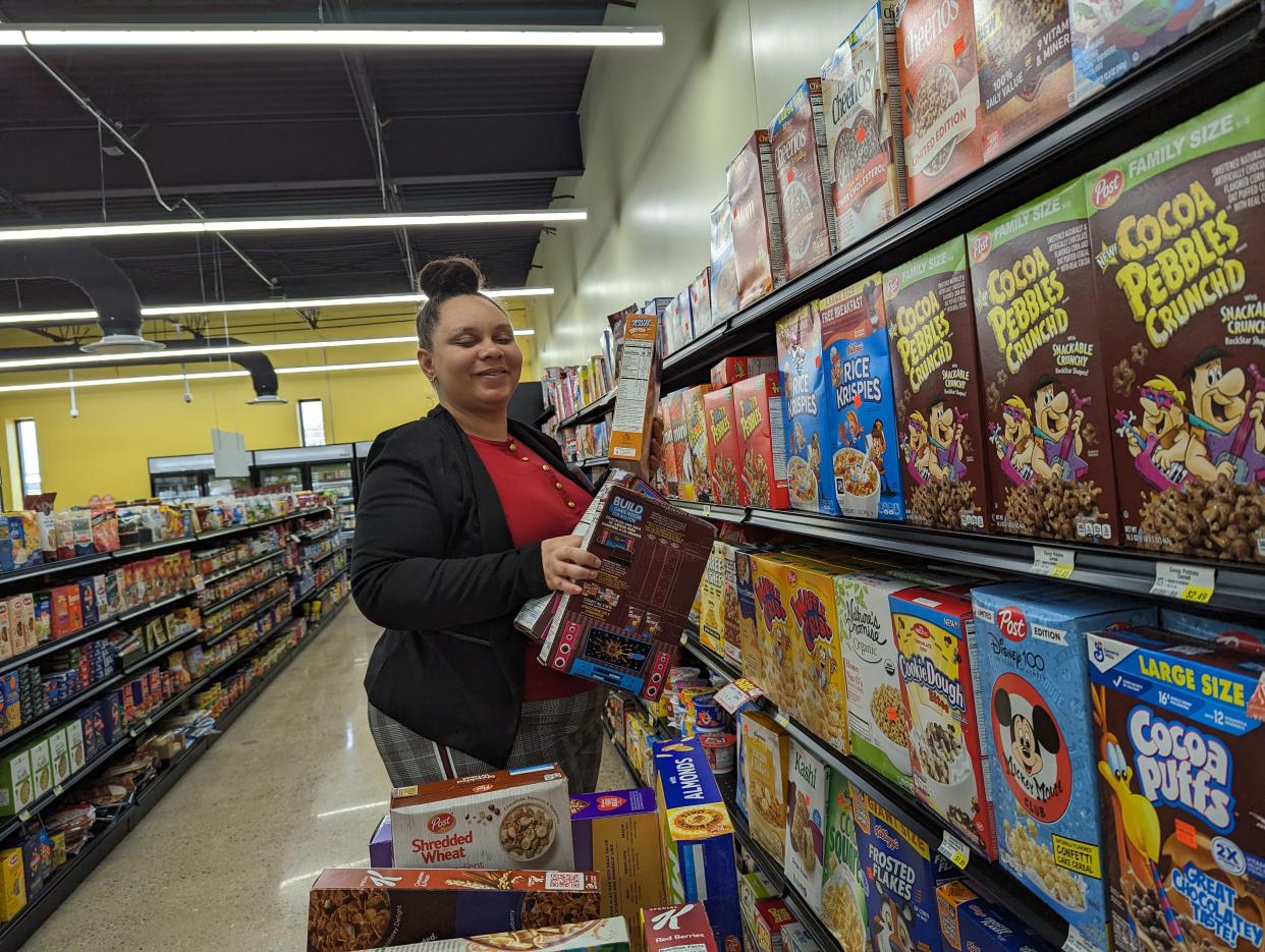 Carliesha Jackson stocks shelves at Sommers Discount Market at Southeast Market Plaza, which had a ribbon-cutting on Saturday. The new facility at 1318 Gonder Ave SE in Canton also houses a My Community Health Center and was built through public-private partnerships.