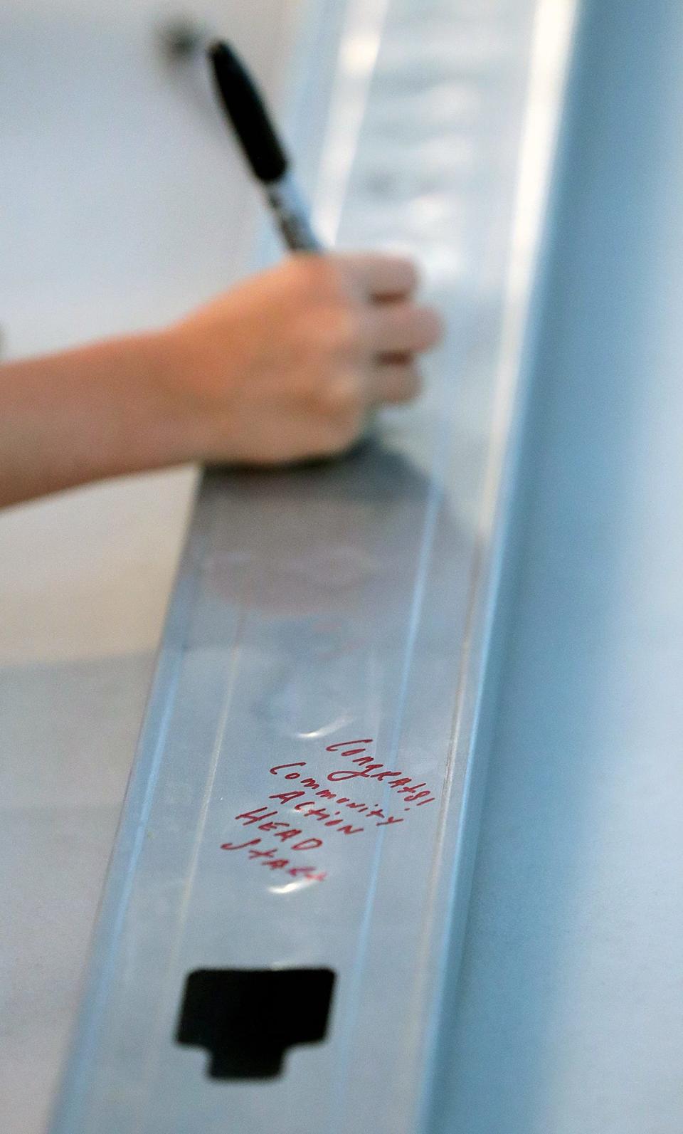 Guests sign the first beam to celebrate the museum's expansion project on Wednesday.