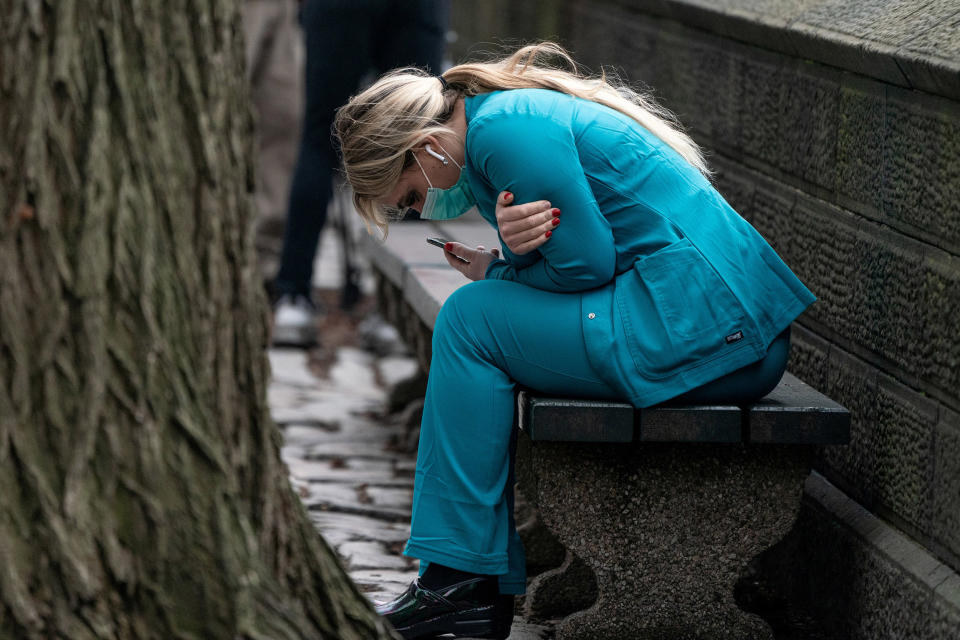 Image: A healthcare worker sits on a bench near Central park in the Manhattan borough of New York City (Jeenah Moon / Reuters)