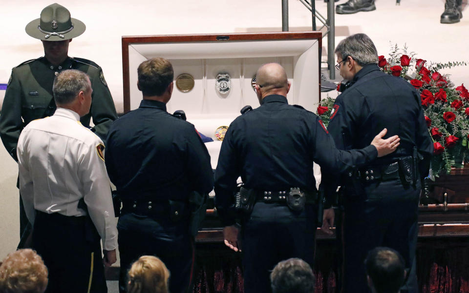 Lawmen console one another during visitation prior to the funeral services Thursday, Oct. 4, 2018, for Brookhaven Police Corporal Zach Moak at Easthaven Baptist Church in Brookhaven, Miss. Moak and officer James White were killed early Saturday, Sept. 30, responding to a call. (AP Photo/Rogelio V. Solis)