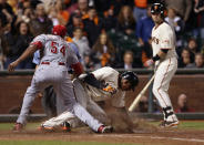 Joaquin Arias #13 of the San Francisco Giants scores on a past ball by pitcher Aroldis Chapman of the Cincinnati Reds in the ninth inning during Game One of the National League Division Series at AT&T Park on October 6, 2012 in San Francisco, California. The Reds defeated the Giants 5-2. (Photo by Jeff Gross/Getty Images)