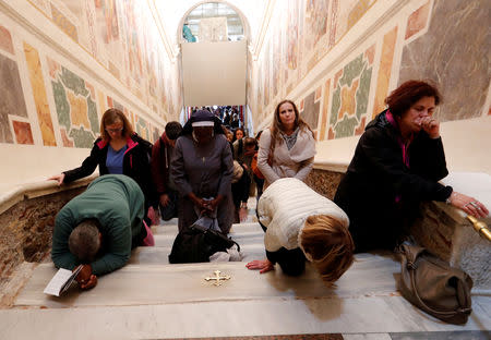 Worshippers pray on the Holy Stairs in Rome, Italy April 16 2019. REUTERS/Remo Casilli