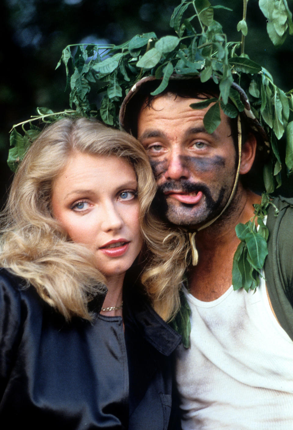 Cindy Morgan and Bill Murray nestled behind a tree in a scene from the film 'Caddyshack', 1980. (Photo by Orion Pictures/Getty Images)