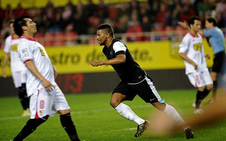 Malaga's midfielder Eliseu (C) celebrates after scoring a goal during their Spanish league football match against Sevilla at the Ramon Sanchez Pizjuan stadium in Sevilla on December 15, 2012