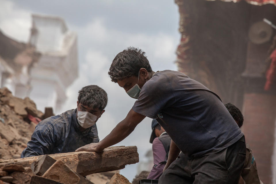 Volunteers clear debris of a collapsed temple at Basantapur Durbar Square on April 27, 2015 in Kathmandu, Nepal.  (Photo by Omar Havana/Getty Images)