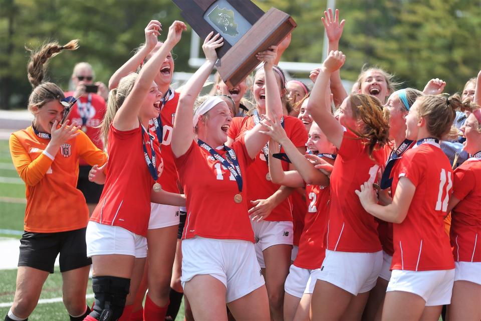 Chatham Glenwood's Ali Matthews hoists the Class 2A girls soccer state title after the Titans defeated Lisle Benet Academy 2-0 in double overtime at Benedetti–Wehrli Stadium in Naperville on Saturday, June 3, 2023.