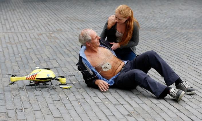 A woman gives a demonstration of an ambulance drone with built in defibrillator at the campus of the Delft Technical University in Delft on October 28, 2014. A Swedish report Tuesday said drones can drastically cut response times for delivering the life-saving equipment to victims. (AFP Photo/BAS CZERWINSKI)