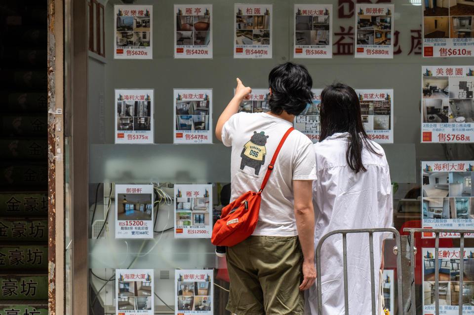 HONG KONG - 2022/03/30: A couple looks at real estate listings. Hong Kong's housing rental prices are at their lowest level in two years, with concerns over the fifth wave of COVID-19 as well as other economic indicators leading to further price reductions. (Photo by Ben Marans/SOPA Images/LightRocket via Getty Images)