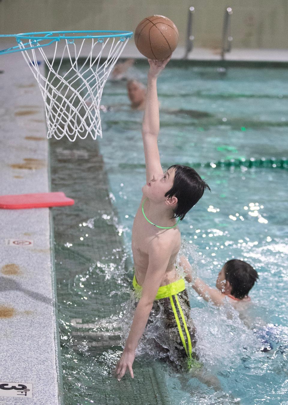 Aaden Marthan, 10, shoots a basket during pool time at the Massillon YMCA School Day Off Kid Care program.