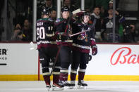 Arizona Coyotes defenseman Jakob Chychrun (6) celebrates with defenseman J.J. Moser (90) and right wing Clayton Keller after scoring a goal against the Minnesota Wild in the second period during an NHL hockey game, Monday, Feb. 6, 2023, in Tempe, Ariz. (AP Photo/Rick Scuteri)