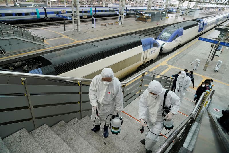 Employees from a disinfection service company sanitize the floor of Seoul Railway Station in Seoul