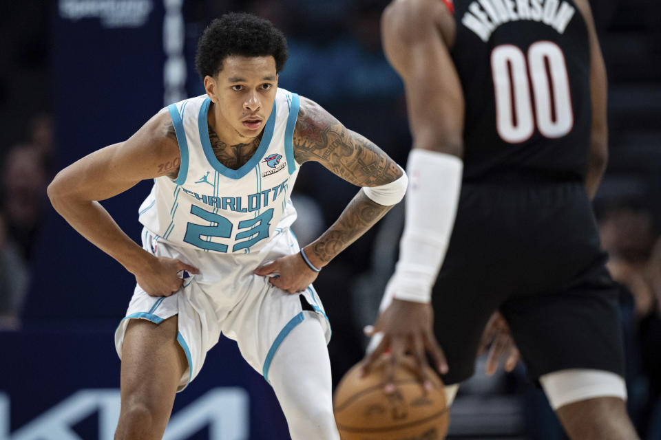 Charlotte Hornets guard Tre Mann (23) guards Portland Trail Blazers guard Scoot Henderson (00) during the first half of an NBA basketball game Wednesday, April 3, 2024, in Charlotte, N.C. (AP Photo/Jacob Kupferman)