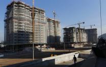 A worker walks at the construction site of the Rio 2016 Olympic Games athletes village in Rio de Janeiro June 27, 2014. REUTERS/Ricardo Moraes (BRAZIL - Tags: SPORT OLYMPICS BUSINESS CONSTRUCTION)