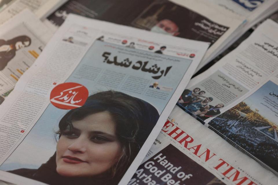 A newspaper with a cover picture of Mahsa Amini (VIA REUTERS)