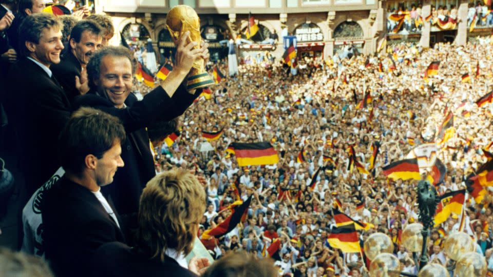 Beckenbauer celebrates with the World Cup trophy in 1990. - Kai-Uwe Wärner/dpa/picture-alliance/AP