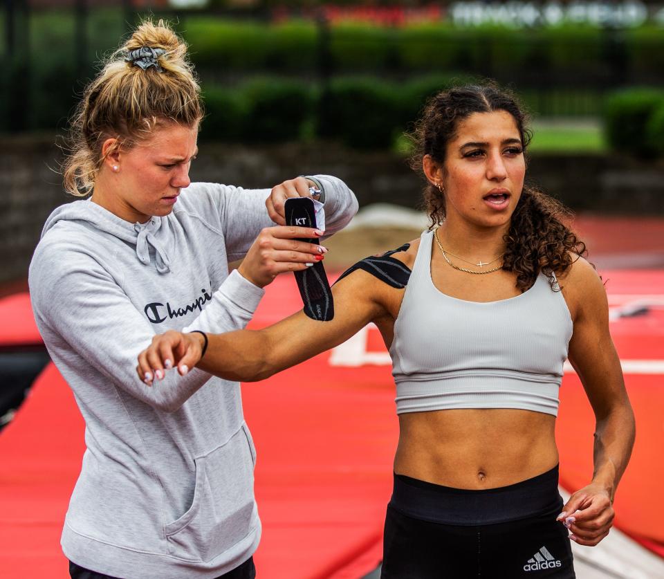 U of L pole vaulter Gabriela Leon gets her arm taped up by her teammate Aliyah Welter before practicing at the Cardinal Track Stadium in Louisville, Ky on July 9, 2022.