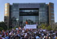 Supporters of a Christian party (the Free Patriotic Movement) protest in front the U.N headquarters against the Syrian refugees and the deal between the European Union and the Lebanese government, in Beirut, Thursday, May 9, 2024. Hundreds of Syrians refugees left a remote northeastern Lebanese town back to Syria in a convoy Tuesday, amid a surge in anti-refugee sentiment in the small, crisis-hit country. The Arabic banner, centre, reads:"Lebanon is for Lebanese not for other people, Lebanon not for sale." (AP Photo/Hussein Malla)