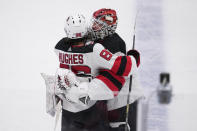 New Jersey Devils' Jack Hughes and Vitek Vanecek (41) celebrate after Hughes scored in overtime of an NHL hockey game against the Dallas Stars, Friday, Jan. 27, 2023, in Dallas. The Devils won 3-2. (AP Photo/Tony Gutierrez)