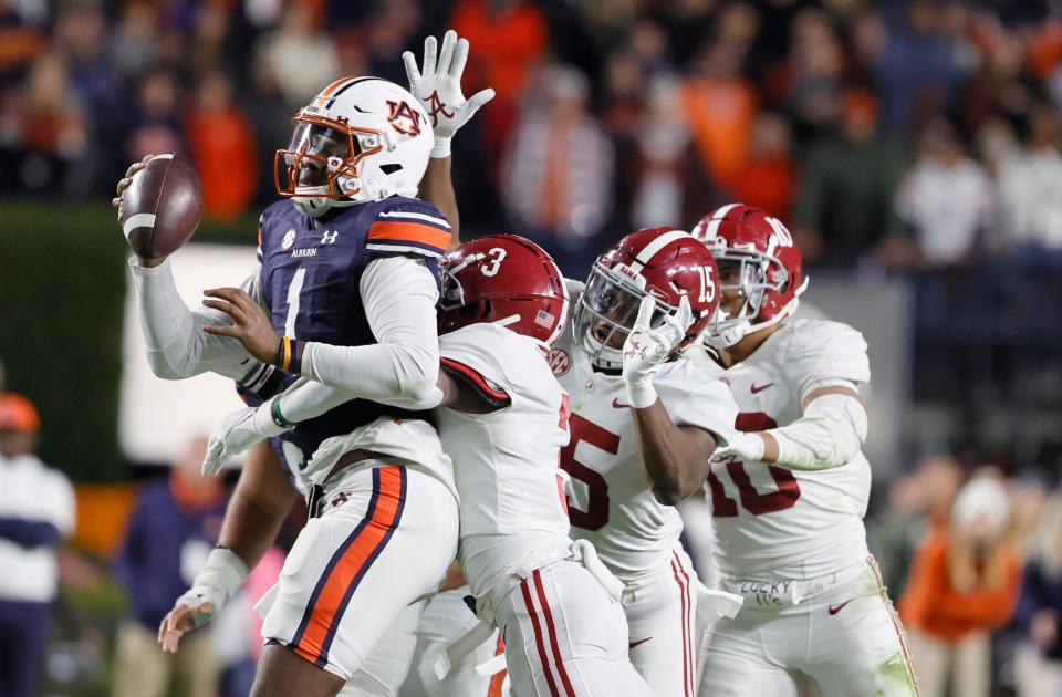 Nov 27, 2021; Auburn, Alabama, USA; Auburn Tigers quarterback TJ Finley (1) is tackled by Alabama Crimson Tide defensive back Daniel Wright (3) in the second overtime period at Jordan-Hare Stadium. The Alabama Crimson Tide won in the fourth overtime period. Mandatory Credit: John Reed-USA TODAY Sports