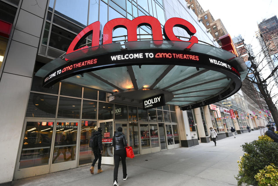 People walk in front of the AMC Theater in New York.