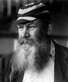 Man with large beard and wearing a striped hat.