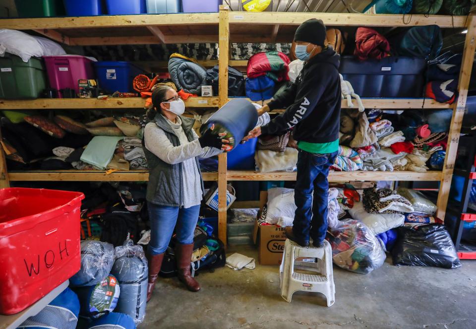 Pastor Christie Love, of the Connecting Grounds, and John Reier go pull down sleeping bags before heading out to distribute cold weather gear to the homeless on Wednesday, Oct. 28, 2020.