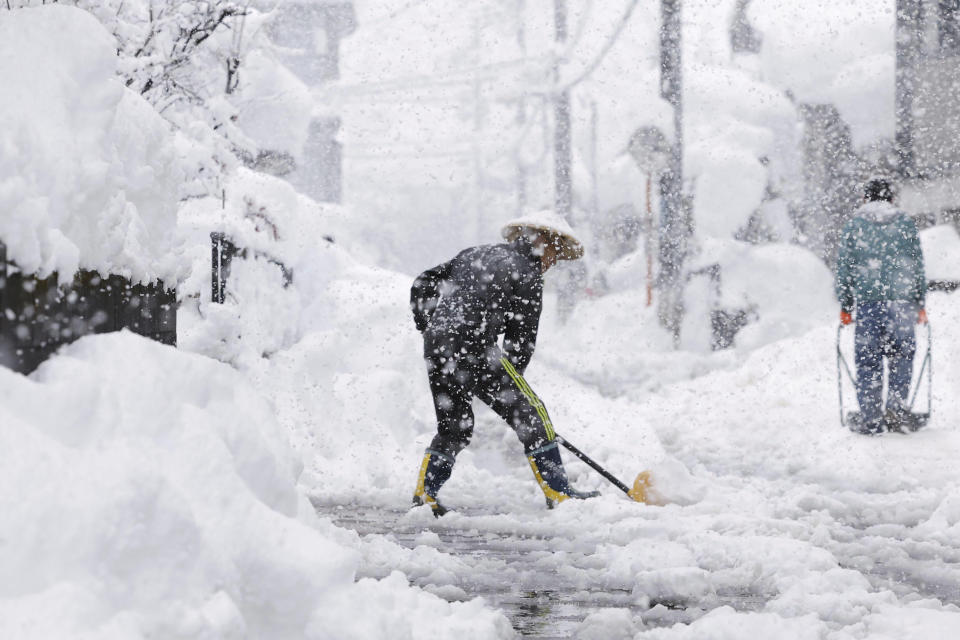 Residents remove snow during heavy snow Monday, Dec. 19, 2022 in Nagaoka, Niigata prefecture, northern Japan.(Kyodo News via AP)