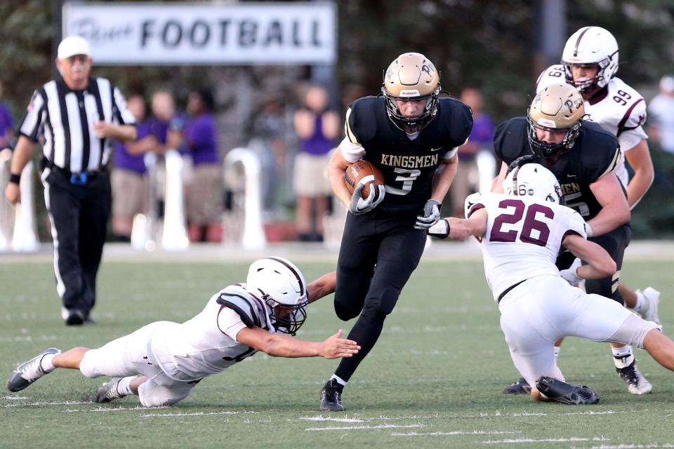 Penn wide receiver Kellen Watson (3) runs while Mishawaka defender Jackson Snyder (26) tries to tackle him during the Mishawaka vs. Penn football game Friday, Aug. 25, 2023, at Freed Field. The Kingsmen won over the Cavemen, 28-7.