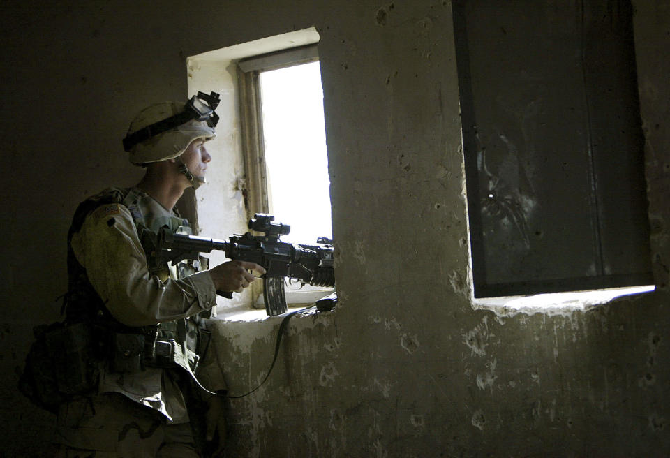 FILE - In this April 29, 2003, file photo, U.S. soldier mans a position from a primary school window in Fallujah, Iraq. The U.S. launched its invasion of Iraq on March 20, 2003, unleashing a war that led to an insurgency, sectarian violence and tens of thousands of deaths. (AP Photo/David Guttenfelder, File)