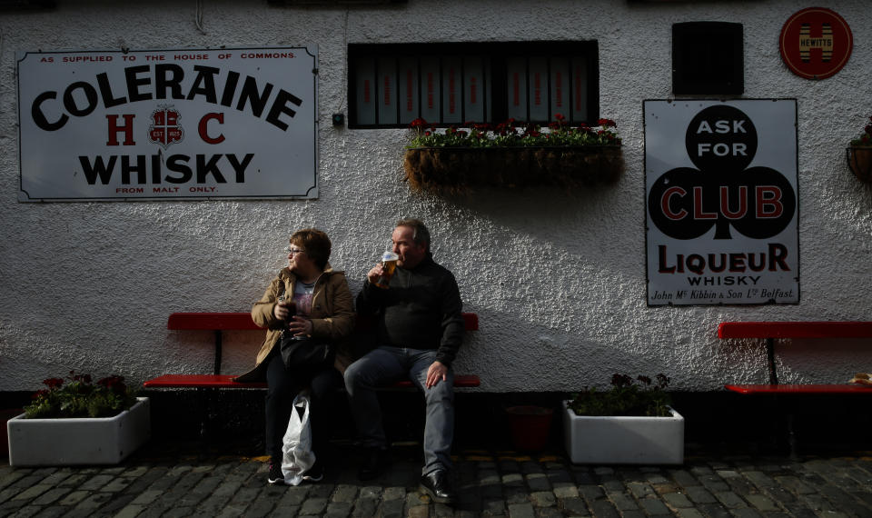 A couple of Scottish tourists sit in the late afternoon sun and enjoy a quiet drink outside the Duke of York pub in Belfast, Northern Ireland, Friday, March 24, 2017. Almost 20 years on from the Good Friday peace accord, which brought about the end of Northern Ireland's sectarian conflict, the city of Belfast has changed dramatically. Reminders of the past are everywhere _ murals and memorials to those killed in the conflict, along with peace walls that separate predominantly Protestant neighborhoods from mostly Catholic ones _ but there are also new shopping malls and cafes, new tech industries, and lots of tourists. (AP Photo/Alastair Grant)