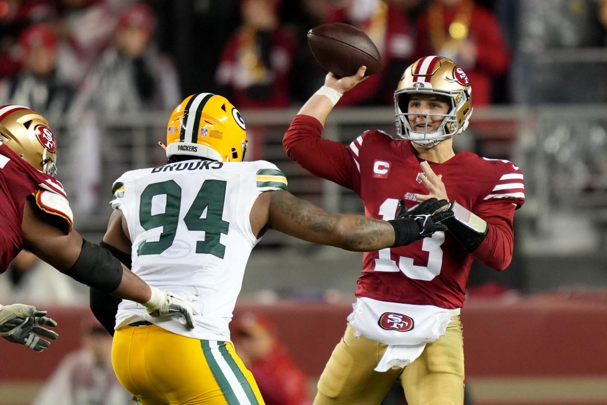 San Francisco 49ers quarterback Brock Purdy passes under pressure from Green Bay Packers defensive tackle Karl Brooks.