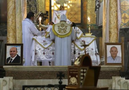 A picture of Medhat Michel, on the left, and a picture of Waguih Mourise, two of the Christian victims of the crashed EgyptAir flight MS804, are seen during an absentee funeral mass at the main Cathedral in Cairo, Egypt, May 22, 2016. REUTERS/Mohamed Abd El Ghany