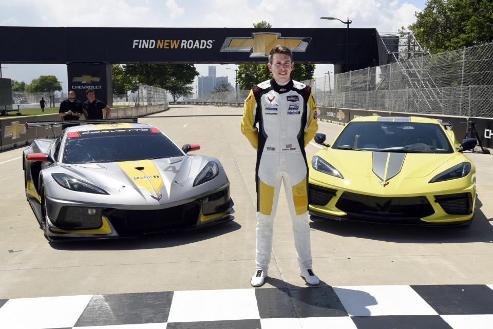 Tommy Milner stands in front of a Corvette C8.R race car, left, and a 2022 Corvette Stingray IMSA GTLM Championship Edition road car following a news conference at Raceway at Belle Isle, Wednesday, June 9, 2021, in Detroit. With Le Mans rescheduled to August, the conflict that had prevented Corvette from competing at Belle Isle had been eliminated and the two-car program will race Saturday in GM's backyard for the first time since 2008. (AP Photo/Jose Juarez)