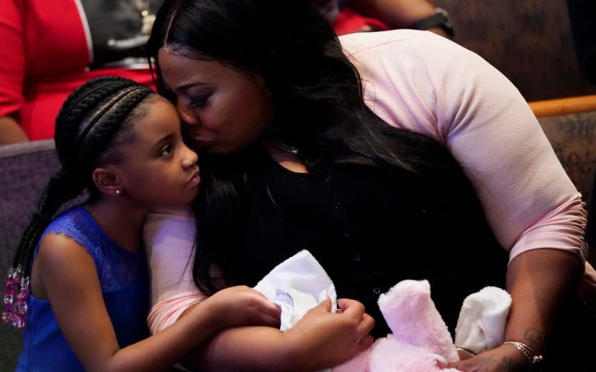 Roxie Washington holds Gianna Floyd, her daughter with George Floyd, as they attend his funeral service at The Fountain of Praise church in Houston - DAVID J. PHILLIP/AP